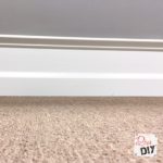 Cheap and easy Home Improvement DIY to add drama to builder grade baseboards by adding trim to your walls and painting the space between them.