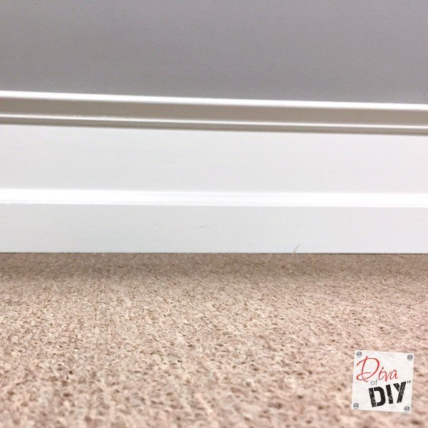 Cheap and easy Home Improvement DIY to add drama to builder grade baseboards by adding trim to your walls and painting the space between them.